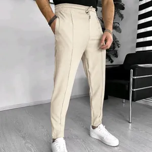 Modern men's beige waffle knit drawstring pants shown on a model for a stylish casual slim fit