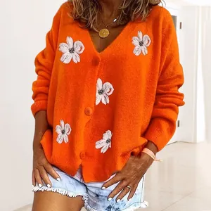 Cardigan in maglia arancione vintage con ricami floreali bianchi e bottoni.