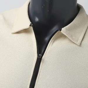 Macro detail showing the collar and zipper of a cream waffle knit men's polo jacket