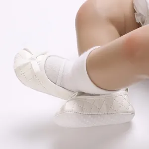 Close-up of white quilted baby Mary Jane shoes with delicate bow and soft anti-slip sole