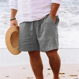 Uomo casual che indossa pantaloncini grigi in cotone e lino sulla spiaggia assolata