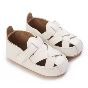 Dettaglio di scarpe primi passi bianche per neonati con suola morbida intrecciata