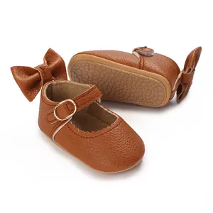 Detail view of brown baby girl walker shoes showing non-slip sole and bow accent.