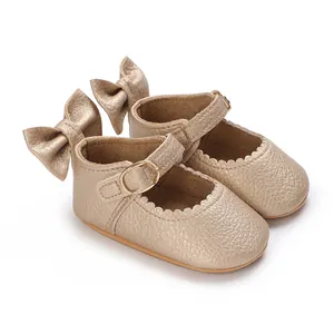 Detailed view of gold baby girl walking shoes with heel bow and metal buckle closure.