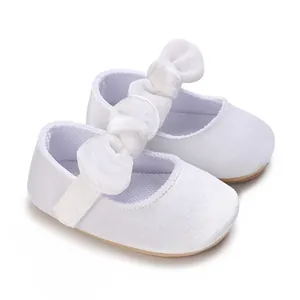 Elegant white baby girl baptism shoes with decorative large bows and soft soles.