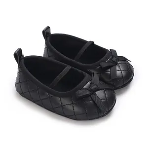 Detail view of black quilted baby girl flat shoes featuring a cute bow and elastic strap