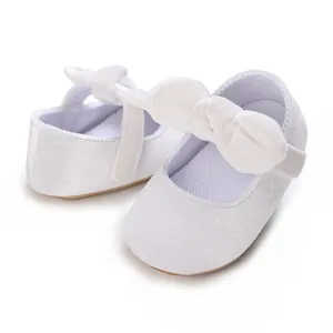 Soft white baby girl princess baptism shoes featuring an elegant large bow detail