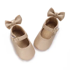 Detailed top view of gold infant walking shoes with bow decoration and buckles