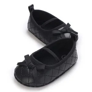 Close-up of black quilted baby Mary Jane shoes with grosgrain bow and elastic strap