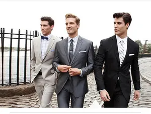 Drei elegante Männer in professionellen Business-Anzügen in einer Outdoor-Hochzeitsumgebung