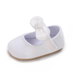 Detailed view of the soft white fabric and large bow on this baby girl christening shoe