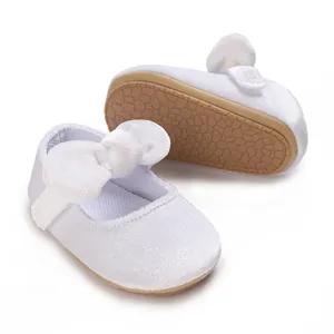 Detail view of white baby girl princess shoes with bow and soft non-slip sole