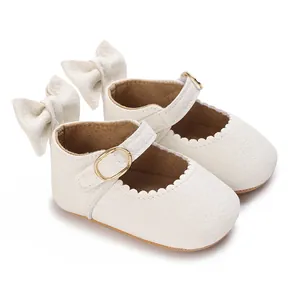 Detailed view of white baby girl walker shoes with leather texture and gold buckle
