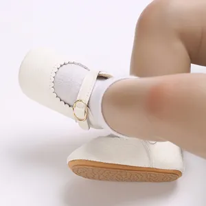 Close-up of white baby girl walking shoes with scalloped edges and non-slip rubber sole