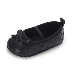 Detail shot of a black quilted baby girl flat shoe featuring a cute bow and elastic strap