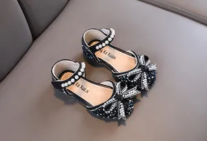 Vista detallada de zapatos de princesa negros para niña con lazo de diamantes