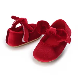 Detailed view of red velvet baby girl princess shoes with a large decorative bow