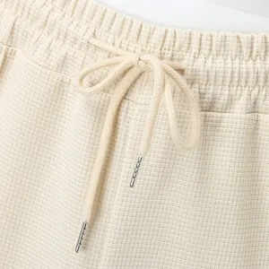Close-up of men's waffle knit drawstring waistband with premium metal aglets detail.
