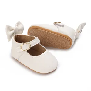 Detailed view of white baby girl walking shoes with a delicate bow and non-slip sole