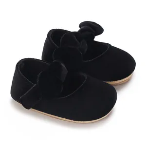 Detail view of black velvet baby princess shoes with a soft sole and large bow