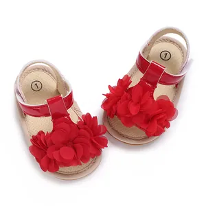 Primer plano detallado de sandalias de verano rojas para bebé con grandes flores de tela en relieve