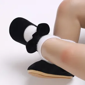 Close-up of cute black velvet baby girl Mary Jane shoes with a bow detail and soft sole walker.