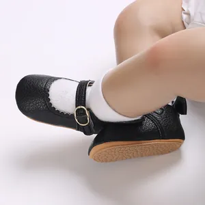 Macro detail of black scalloped baby walker shoes featuring anti-slip rubber sole