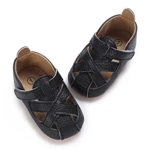 Dettaglio dei sandali neri per neonati con suola morbida e pratici cinturini in velcro.