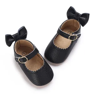 Detailed view of black baby Mary Jane shoes with back bows and scalloped edge design