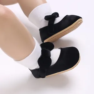 Detail view of black velvet baby girl shoes featuring a cute bow and flexible soft sole.