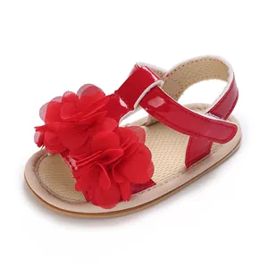 Detalle de sandalia roja para bebé niña con flores decorativas y acabado de charol brillante