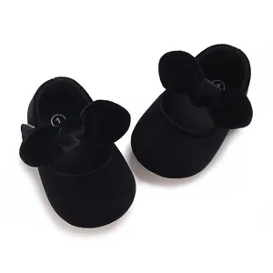 Overhead view of elegant black velvet baby girl princess shoes with large decorative bow