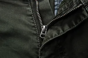 Detailed macro view of a sturdy metal zipper on olive green cotton cargo pants fabric texture