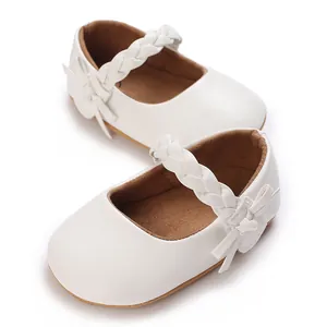 Detailaufnahme von weißen Baby-Mädchen-Mary-Jane-Schuhen mit geflochtenem Riemen