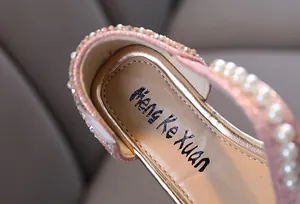 Vista detallada del zapato de princesa rosa para niña con elegantes detalles de perlas y strass
