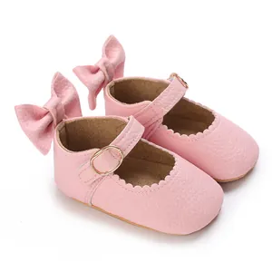 Detail of pink baby Mary Jane shoes with large bow and wavy edges for infant girls
