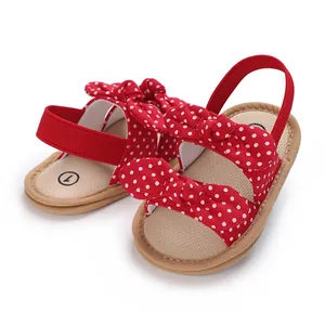 Detalle de las sandalias rojas de lunares para bebé con suelas blandas y lazos