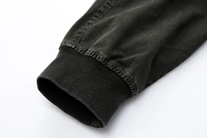 Macro view showing the elastic ribbed cuff and washed texture of men's cargo pants.