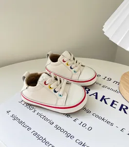 Detailansicht von cremefarbenen Lauflernschuhen für Babys mit bunten Ösen.