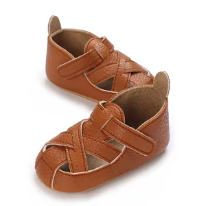 Primo piano di scarpe da passeggio per bambini in ecopelle marrone con suole morbide.