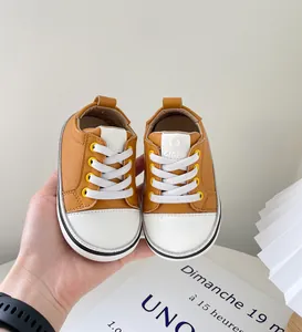 Nahaufnahme von braun-weißen Lauflernschuhen mit weicher Sohle für Kleinkinder
