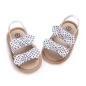 Detalle de sandalia de paseo para bebé niña con lazos de lunares blancos y negros
