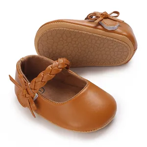 Nahaufnahme brauner Lauflernschuhe für Babys mit rutschfester Gummisohle und Flechtriemen