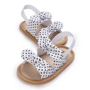Sandalias suaves para bebé en blanco con lunares negros y lindos detalles de lazo