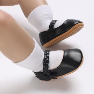 Nahaufnahme von schwarzen Baby Mary Jane Lauflernschuhen mit geflochtenen Riemen