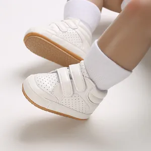 Detailed view of white leather baby walker sneakers featuring non-slip gum soles.