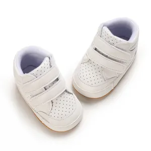 Top-down view of white leather baby boy toddler shoes with double velcro straps.