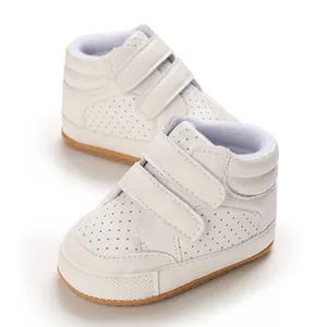 Close-up of white baby leather pre-walker shoes with perforated design and velcro straps