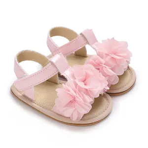 Detalle de sandalias rosas para bebé con suela blanda y flores decorativas.