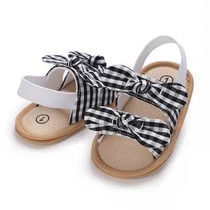 Detalle de zapatos de verano para bebés con lazos de cuadros vichy en blanco y negro